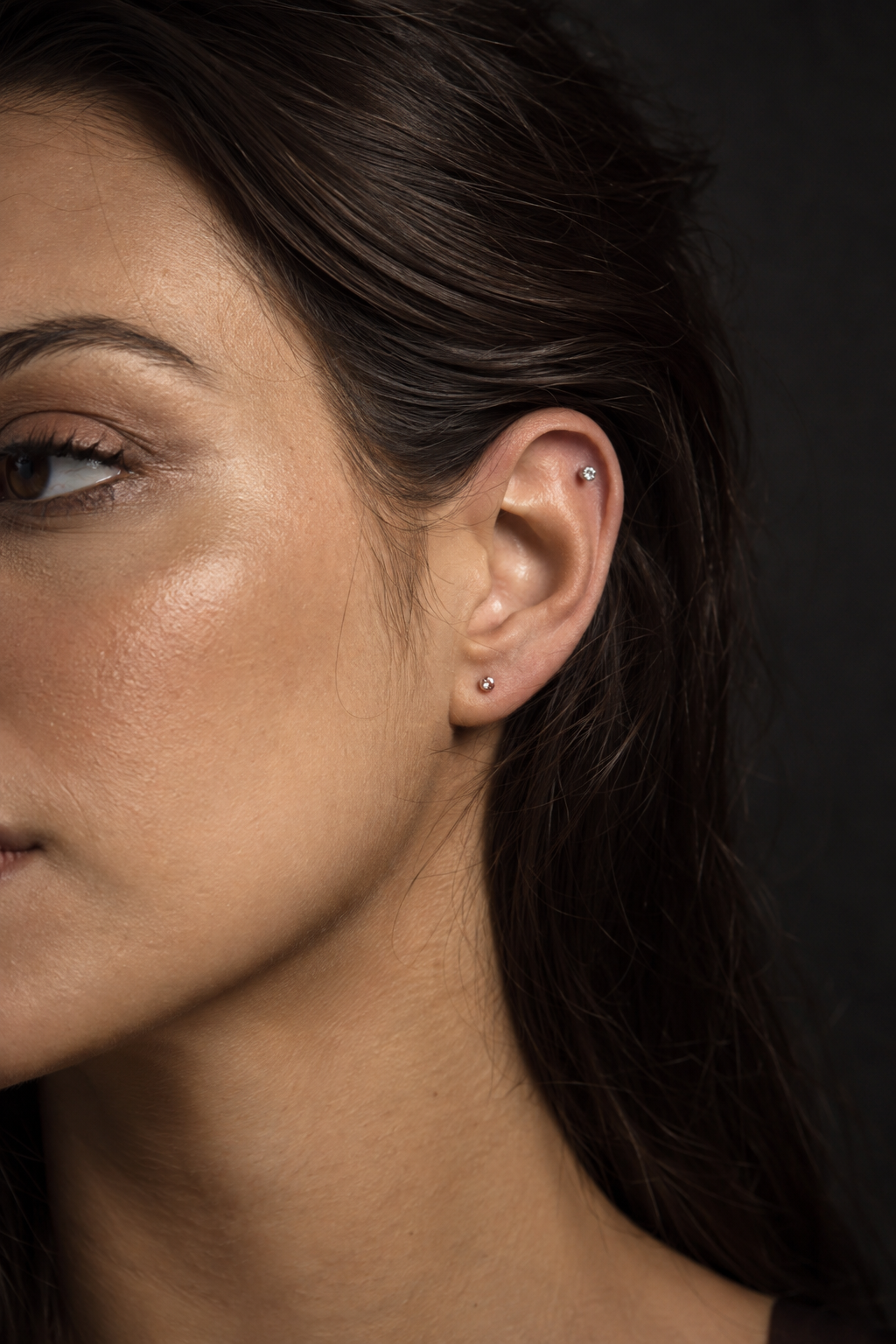 Imagem editorial ilustrativa de modelo com piercings delicados na orelha